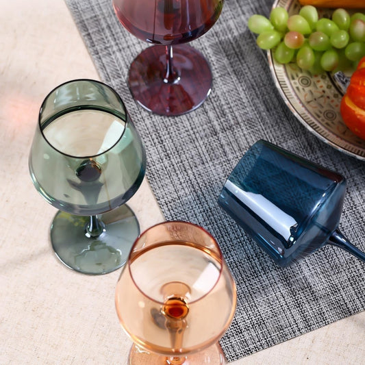 Colored wine glasses catching light on a table setting