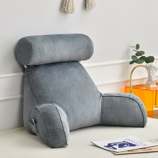 Lounge back pillow with padded armrests and adjustable headrest on a bed