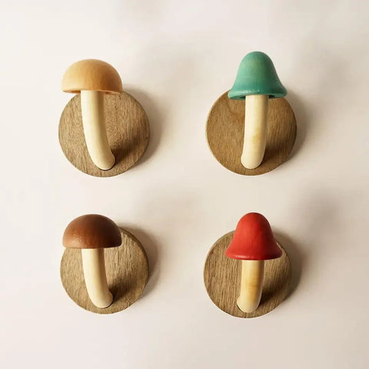 Set of four colorful wooden mushroom wall hooks mounted on wall