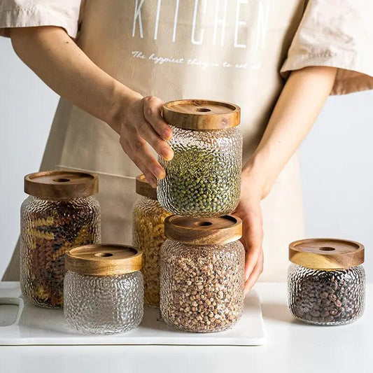 Textured glass storage canister with wooden lid holding coffee beans
