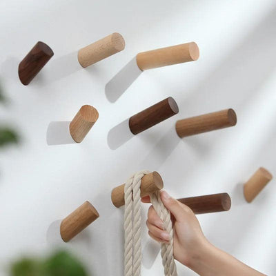 Wood wall hook holding a coat in an entryway