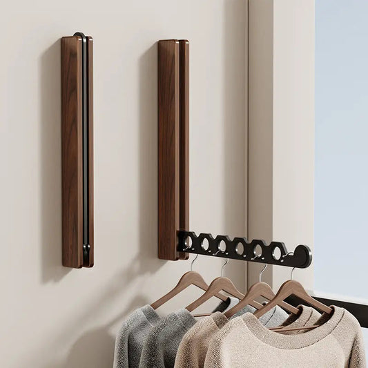 Wall mounted folding rail holding coats in entryway