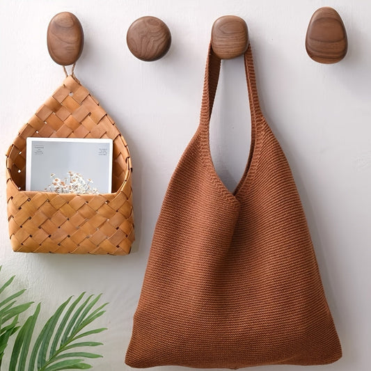 Walnut pebble shaped wood wall hooks mounted in a row on neutral wall