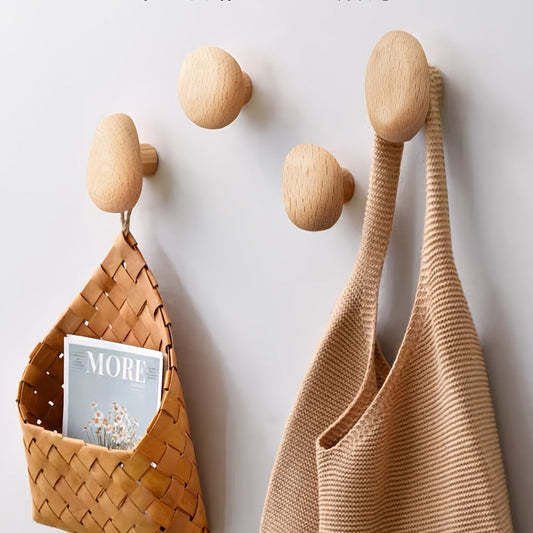 Set of four wooden pebble wall hooks in assorted sizes