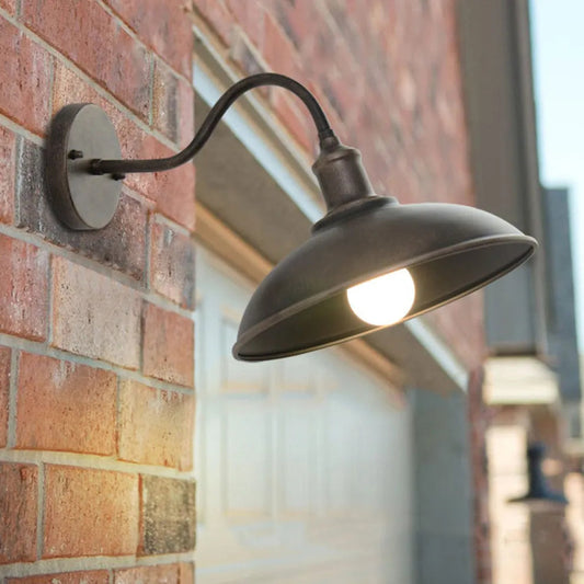 Vintage bronze barn sconce with gooseneck arm on exterior wall