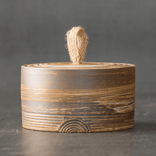 Wabi sabi ceramic lidded jar with hemp rope pull on shelf