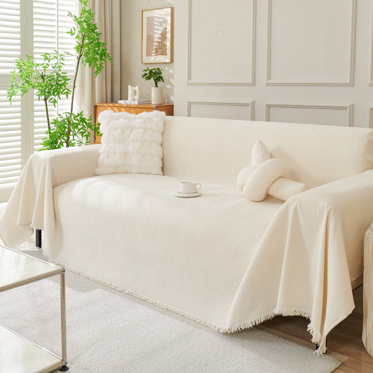 Almond milk boho woven sofa cover draped over a couch in a bright living room