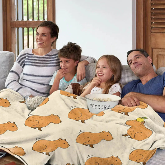 Orange capybara print flannel throw blanket on bed