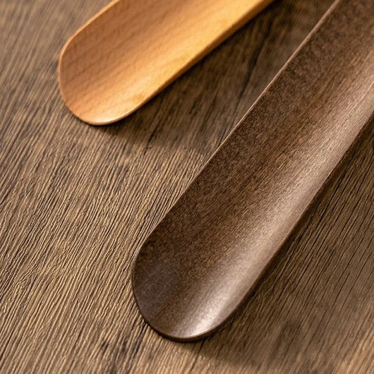 Magnetic wall base holding wooden shoehorn beside front door