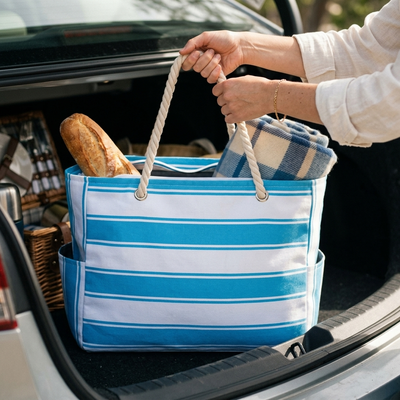 Blue stripe beach tote lifted from car trunk packed for picnic