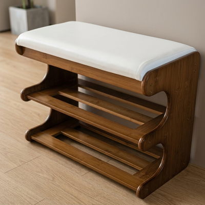 Close angle of brown bamboo shoe bench showing slatted shelves and white leather cushion