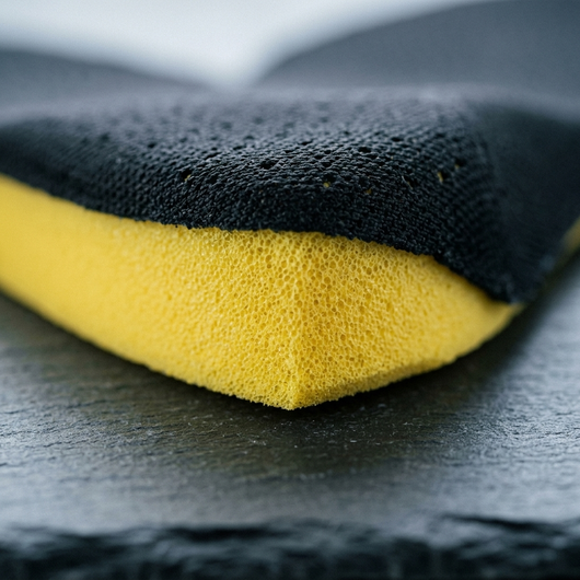 Close up of perforated fabric top and yellow EVA foam heel wedge on height increasing insole
