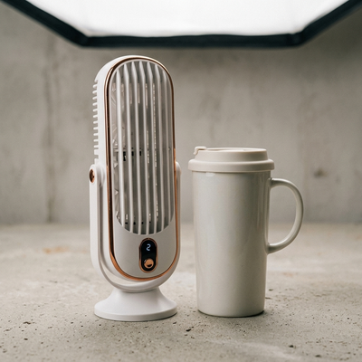 White dual motor rotating tower fan size compared to travel mug