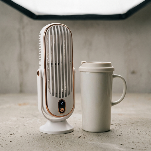 White dual motor rotating tower fan size compared to travel mug