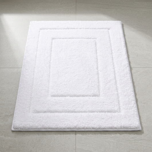 Geometric microfiber bath mat laid flat on a tile bathroom floor