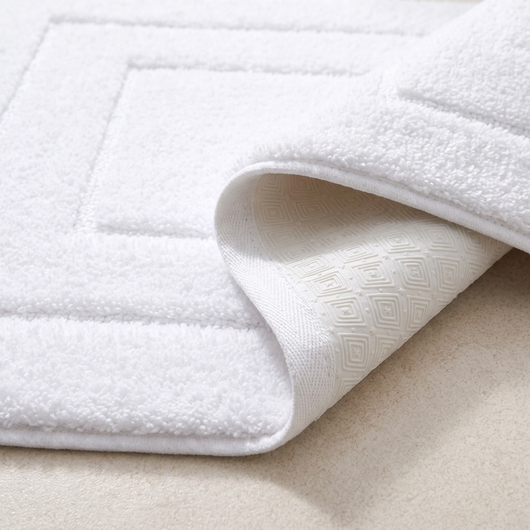 Corner of the bath mat folded back showing the textured TPR backing