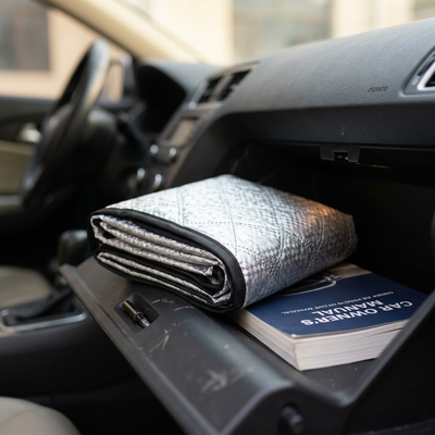 Windshield cover folded into a compact bundle inside a car glove box