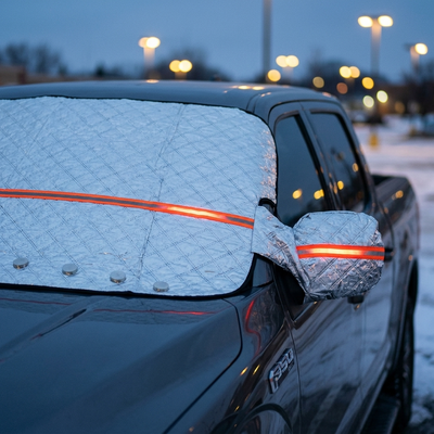 Thickened windshield cover with reflective stripe on a pickup truck at dusk