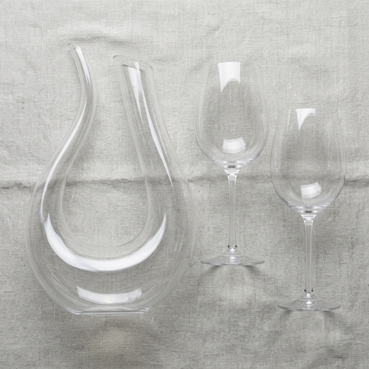 Overhead flat lay of the decanter and two stemmed glasses on linen