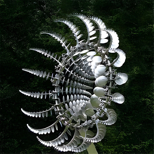 Bronze dual rotor kinetic wind spinner staked in a garden bed